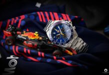 The TAG Heuer Aston Martin Red Bull is part of the Formula 1 collection that the Swiss watchmaker released together with Red Bull Racing. An exciting daily rocker with racer genes or rather something for die-hard Formula 1 fans? I took a closer look at the quartz chronograph for you. Your online store for luxury watches: the Uhrenlounge Nowadays, luxury watches from well-known manufacturers are usually bought on the Internet. Especially here it is important to find a suitable and reputable provider. This is where the Uhrenlounge comes into play. For this review, I once again collaborated with the online portal of Aika Juweliere Dresden, who kindly provided me with the TAG Heuer Aston Martin Red Bull. It's worth a look at the homepage! The Uhrenlounge carries more than twenty selected brands on their site, so everyone should find what they are looking for. You can also order TAG Heuer's Aston Martin Red Bull there. As always, you'll find all the important links at the end of this review!  Why you should watch Formula 1 again! At the moment it is worth to watch Formula 1. This is not only due to the world championship battle, which has gained in excitement again in the 2021 season, but also due to the advertising - right, the watch advertising. You can find them on boards, as sponsor stickers on the cars, and last but not least on the wrists of the drivers, pretty much every one of them is equipped with a luxury watch.  Watch brands and Formula 1 – that fits!. No wonder, precision, perfection and performance are probably characteristics that are highly appreciated on both sides. In recent years, this has led to more and more manufacturers finding their way into Formula 1. While Rolex, for example, is the main sponsor of the series, most racing teams also have a designated watch partner. Mercedes IWC, Ferrari and McLaren Richard Mille and four-time world champion Red Bull TAG Heuer. The traditional Swiss company and the Austrian racing team have been cooperating for several years. And since Red Bull star Max Verstappen is currently a permanent guest on the podium and competing for the world championship title, he can often be seen in interviews. Always on his wrist: one of TAG Heuer's premium watches from the Formula 1 collection. This includes the TAG Heuer Aston Martin Red Bull with the reference number CAZ101AB.BA0842. Will it perform as well as the current Red Bull car? The Unboxing TAG Heuer has put a lot of thought into the design and you can see that. Maybe not at first glance, but at the latest when you open the black packaging and admire the inner workings for the first time. In the dark blue lined box, the watch is on a red-yellow cushion. So everything matches the color design of the racing team. I also like the glossy warranty card next to it with the team logo.  The TAG Heuer Aston Martin Red Bull itself is a chronograph in the books: self-confident, masculine, classy and sporty. This is mainly due to the combination of stainless steel and dark blue dial, which is softened by red and yellow color accents. A tachymeter on the bezel, three totalizers and two pushers also give the impression that this watch can clearly do more than "just" look good. But more about the details later.  The big Formula 1 fans among you might also be interested in the enclosed brochure. Here you can find more information about the partnership between TAG Heuer and the racing team. The TAG Heuer Aston Martin Red Bull on the wrist A visually good appearance is far from being everything, but it is not unimportant nonetheless. And from the first time you put it on, you simply have to acknowledge without envy that the TAG Heuer Aston Martin Red Bull is convincing all along the line here. The classic look is without question timeless. The design is sporty, but also proves enough style consciousness for everyday life and therefore fits every occasion. Intermediate conclusion: a men's watch that you can always wear, just a real daily rocker. With a diameter of 43 millimeters, the TAG Heuer Aston Martin Red Bull has a size that is slightly above average, but never seems too bulky or overbearing. This chronograph will fit any wrist. As a quartz watch, the TAG Heuer Aston Martin Red Bull is not too thick. It therefore lies quite flat on the wrist. The case: very solid and with small details The minimalistic case is approximately round and comes without any small corners or edges. As you would expect from a premium chronograph, it is made of high-quality stainless steel, which ensures durability and robustness against external influences. I like the finish of the case surfaces very much. These are both polished and satin-finished, which gives the TAG Heuer Aston Martin Red Bull a dynamic appearance. The bezel sits on top of the case.  What I really like is the back. The six-screw, solid caseback has been sunburst finished in the manufacturing process, which makes it look particularly classy. In the center, neatly engraved into the stainless steel, is the logo of the successful Formula 1 team: Aston Martin Red Bull Racing. Below that, a checkered pattern reminiscent of the black and white checkered flag. Let's briefly note: at this point, the racing theme was quite beautifully implemented! Thanks to the solid caseback, the TAG Heuer Aston Martin Red Bull is water resistant to a depth of 200 meters. Thus, the racing chronograph can even keep up with many diver's watches. To withstand a pressure of 20 bar at these depths, TAG Heuer uses resistant sapphire crystal on the front.  Quartz movements have their advantages  The watches in TAG Heuer's Formula 1 collection are usually distinguished by their quartz movements. If you think about it in more detail, this is a good choice. A quartz movement is much lighter and more compact, which noticeably lowers the overall weight of the chronograph and reduces the overall height of the case. In everyday use, the movement also offers the typical chronograph functions, among others: Stop second, 30 minute time and 1/10th of a second. This also makes the TAG Heuer Aston Martin Red Bull interesting for use at the race track. Winding up via the massive stainless steel crown is straightforward. The haptic feedback of the two pushers at 2 and 4 o'clock is very good. Dial and bracelet of the TAG Heuer Aston Martin Red Bull THE highlight of the TAG Heuer Aston Martin Red Bull is without a doubt the dial. We should be grateful to the Swiss watch brand for this rich navy blue hue. Here, TAG Heuer also relies on the sunburst finish familiar from the back. Despite its wealth of information with three totalizers, a date window at 4 o'clock, a minute index on the rehaut and various lettering in white and red, the dial remains uncluttered and easy to read. The second hand provides the yellow color accents. The totalizers offer precisely the functions that thrill racing fans. This also applies to the bezel, which has a tachymeter printed on it. If you measure the time it takes to cover a distance of one kilometer, you can read off the speed at which you are moving. For example, one kilometer takes 30 seconds. The second hand therefore stops at 6 o'clock. On the bezel, you'll find the indication 120, which means that you've been traveling at an average speed of 120 km/h. To round off the successful overall impression, the TAG Heuer Aston Martin Red Bull is delivered with a classic stainless steel bracelet including a folding clasp. A stainless steel bracelet like this is practically timeless and fits every occasion. The wearing comfort during my test days was extremely good. A nice detail: the TAG Heuer logo on the folding clasp. My conclusion about the TAG Heuer Aston Martin Red Bull It's already hard not to like the TAG Heuer Aston Martin Red Bull. The sporty chronograph captivates with its penchant for motorsports. True racers and motorsports fans will have a blast with this watch. Not only because of the exciting look in the Red Bull design. It is also the functions that inspire and guarantee a successful day at and on the race track. Measure lap times to the tenth of a second or calculate average speeds? With the TAG Heuer Aston Martin Red Bull, that's no problem. Nevertheless, the chronograph is ideally suited for everyday use. A lot of stainless steel and a timeless design make the TAG Heuer Aston Martin Red Bull interesting not only for real fans, but also for the masses. That's why I can highly recommend this men's watch to you if you are looking for a masculine daily rocker with sporty genes. In the Uhrenlounge store, the TAG Heuer Aston Martin Red Bull currently costs 1700,- Euro. Finally, my thanks once again to Uhrenlounge for providing me with the watch for this review! More about TAG Heuer and the Formula 1 Aston Martin Red Bull Racing Here you can find the watch in the store TAG Heuer Homepage TAG Heuer Aquaracer GMT Pepsi 300M Calibre 7 Automatic Review Best Men Watches 2021   Spec General EAN 7612533155046  Gender men's watch  Manufacturer TAG Heuer  Collection Formula 1  Model Chronograph 43mm ASTON MARTIN Red Bull Racing Special Edition  Reference number CAZ101AB.BA0842  Case Case material stainless steel  Shape of the case round  Diameter 43mm  Water resistance 200m  Bezel aluminum  Case back screwed solid  Watch glass sapphire crystal  Movement winding quartz  Caliber quartz  Dial Color of the dial blue  Index of the dial dashes  Bracelet Bracelet material stainless steel  Bracelet color silver  Clasp folding clasp  Functions  small second  chronograph  date display  luminous hands  luminous indices  tachymeter scale on the bezel